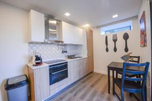 a kitchen with a table and a stove and a sink at Monchique Islet View House T1 in Faja Grande