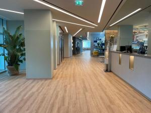an empty hallway in an office with wood floors at H2C Hotel Milanofiori in Assago