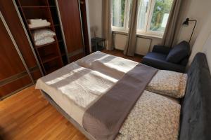 een slaapkamer met een bed, een stoel en een raam bij Apartament MGM Karmelicka in Warschau