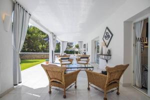 uma sala de estar com cadeiras e uma mesa em Menorca Villa Marbella em Son Parc