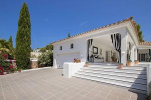 a white house with stairs and a garage at Menorca Villa Marbella in Son Parc