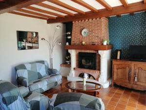 a living room with a couch and a fireplace at Maison calme avec jardin, Petit-Caux in Bracquemont