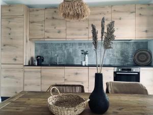 kuchnia z drewnianym stołem z wazonem w obiekcie 3 bedroom ocean shore apartment w mieście Puerto de Santiago