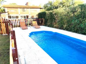 a swimming pool in a yard with chairs next to a house at Sonnen Haus in Villa General Belgrano