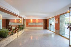an empty lobby with plants in a building at Grand Studio neuf face port et plage, parking privé in Golfe-Juan
