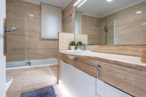 a bathroom with a sink and a tub and a toilet at Hauzify I Apartament Llaó in L'Ametlla de Mar +10 photos