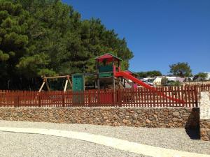 a playground behind a fence with a slide at Easyatent Luxe Safari tent Krk in Krk