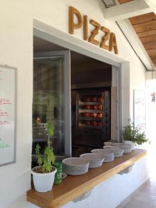 a pizza restaurant with plates and plants on a counter at Easyatent Luxe Safari tent Krk in Krk