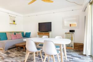 a living room with a table and chairs and a couch at Grand Studio neuf face port et plage, parking privé in Golfe-Juan