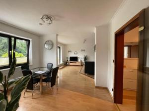 uma sala de estar com uma mesa e cadeiras e uma televisão em Moderne, helle Wohnung mit Terasse 15min bis OB Centro em Dinslaken