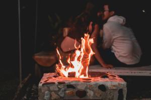 a group of people standing around a fire pit at Glamping Cabañas Sharmont in Guarne
