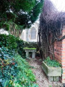 a garden with two benches in front of a building at Churchside @ Mariners in Rhuddlan