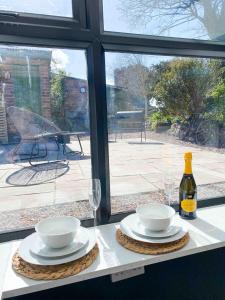 Churchside @ Mariners في Rhuddlan: طاولة مع أطباق وأكواب وزجاجة من النبيذ