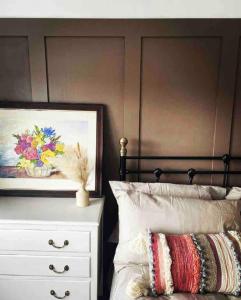 a bedroom with a bed and a painting and a dresser at Churchside @ Mariners in Rhuddlan