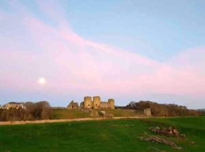 a castle on a hill with a green field at Churchside @ Mariners in Rhuddlan