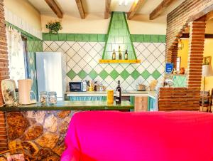 アラウリン・エル・グランデにあるCubo's Finca Jaraのピンクのソファ付きのキッチンが備わる客室です。