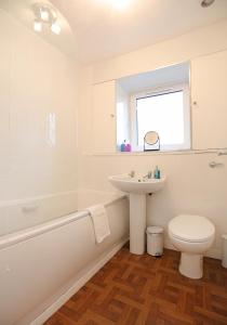 La salle de bains blanche est pourvue d'un lavabo et de toilettes. dans l'établissement The South Maybury Residence, à Édimbourg