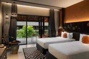 Postel nebo postele na pokoji v ubytování Grand Mercure Khao Lak Bangsak