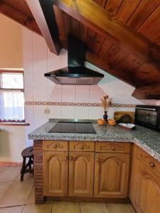 
a kitchen with a stove top oven and a sink at El Invernal de Picos in Portilla de la Reina
