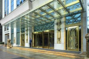a man standing in front of a building with glass doors at Radisson Blu Hotel Shanghai New World in Shanghai