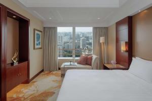 a hotel room with a bed and a large window at Radisson Blu Hotel Shanghai New World in Shanghai