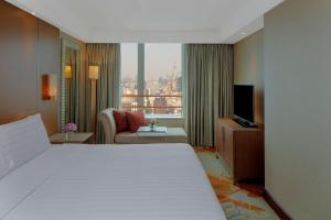 a hotel room with a bed and a television at Radisson Blu Hotel Shanghai New World in Shanghai