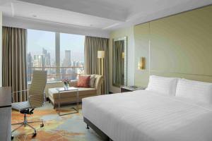 a hotel room with a bed and a couch and a window at Radisson Blu Hotel Shanghai New World in Shanghai