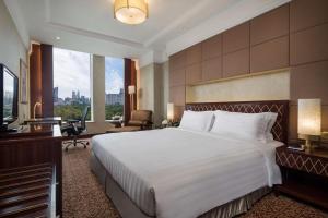 a hotel room with a large bed and a television at Radisson Blu Hotel Shanghai New World in Shanghai