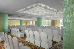 a conference room with white chairs and green walls at Radisson Blu Hotel Shanghai New World in Shanghai