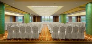 a row of white chairs in a room with green columns at Radisson Blu Hotel Shanghai New World in Shanghai