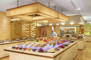 a chef in a kitchen with a buffet of food at Radisson Blu Hotel Shanghai New World in Shanghai
