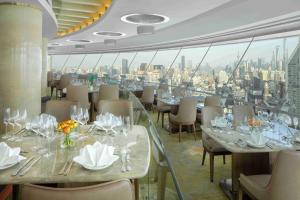 a restaurant with tables and chairs with a view of the city at Radisson Blu Hotel Shanghai New World in Shanghai