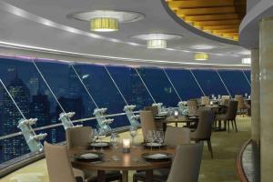 a restaurant with tables and chairs and a view of a city at Radisson Blu Hotel Shanghai New World in Shanghai