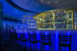 a bar with blue lights in a bar with chairs at Radisson Blu Hotel Shanghai New World in Shanghai