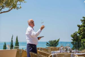 a man holding up a glass of wine at Radisson Blu Resort & Spa in Split