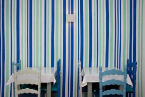 a table and two chairs in a room with striped walls at Villa Miel in Cala Millor