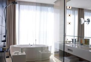 a bathroom with a bathtub, sink and mirror at Radisson Blu Resort & Spa in Split