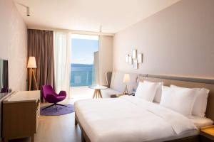a hotel room with a bed and a large window at Radisson Blu Resort & Spa in Split