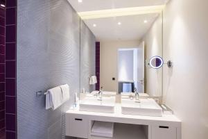 a bathroom with two sinks and a mirror at Radisson Blu Resort & Spa in Split