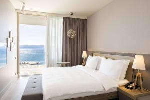 a bedroom with a large bed with a view of the ocean at Radisson Blu Resort & Spa in Split