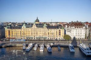 a group of boats docked in the water in front of a building at Radisson Collection, Strand Hotel, Stockholm in Stockholm