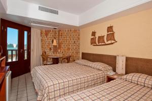 a hotel room with two beds and a table at Rifoles Praia Hotel e Resort in Natal