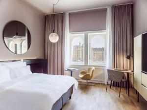 a bedroom with a large white bed and a window at Radisson Collection, Strand Hotel, Stockholm in Stockholm