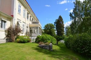 a house with a yard next to a building at Stiftsgården Hostel Skellefteå in Skellefteå