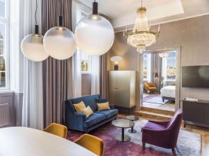 a living room with a blue couch and a table at Radisson Collection, Strand Hotel, Stockholm in Stockholm