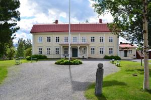 un gran edificio blanco con techo rojo en Stiftsgården Hostel Skellefteå, en Skellefteå