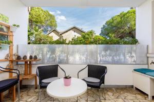a room with a table and chairs and a window at Grand Studio neuf face port et plage, parking privé in Golfe-Juan