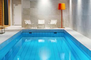 a swimming pool with chairs and a red lamp at Scandic Backadal in Gothenburg