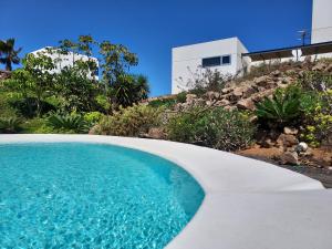 a swimming pool in front of a house at Private villa with pool in Lajares in Lajares