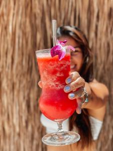 a woman holding a red drink in a glass at Sea Love Beach Bar & Bungalows in Ban Tai